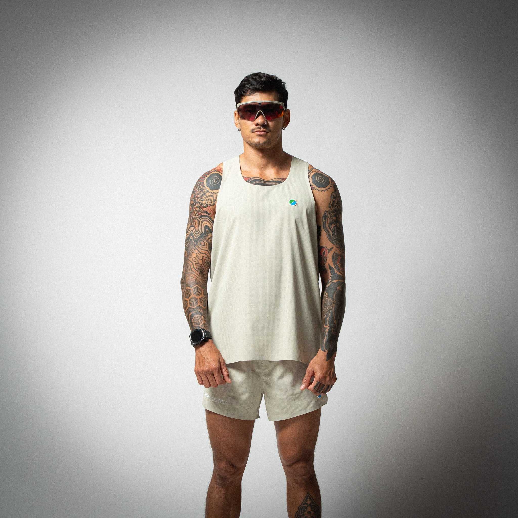 Aeria Fortis Race Tank Beige worn by male model, featuring lightweight breathable design with silicone chest patch.